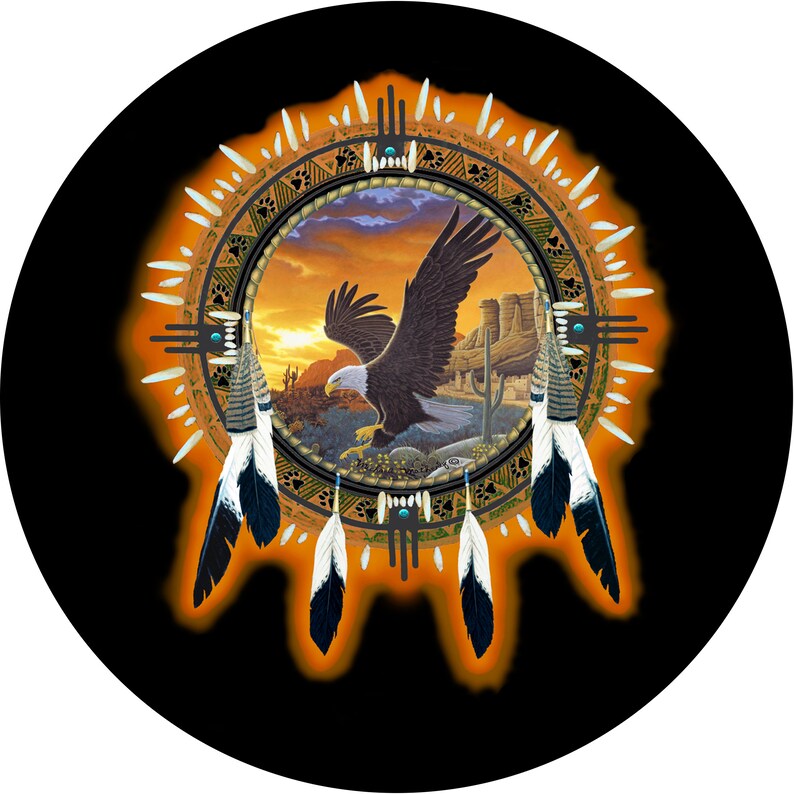 May include: A Native American dreamcatcher with a sunset scene and a bald eagle in flight. The dreamcatcher is decorated with feathers and beads.