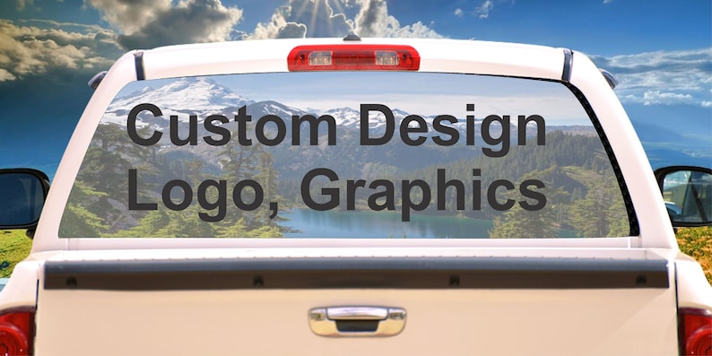 May include: White pickup truck with a custom design window decal that says "Custom Design Logo, Graphics". The decal is on the rear window of the truck and features a scenic mountain landscape.