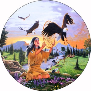 May include: A Native American woman in traditional clothing holds a dreamcatcher with a bald eagle flying above her. The scene is set in a forest with a river and mountains in the background. The sky is a vibrant orange and pink.