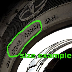 May include: Close-up of a black tire with the text "P245/65R17 105T" printed on the side.
