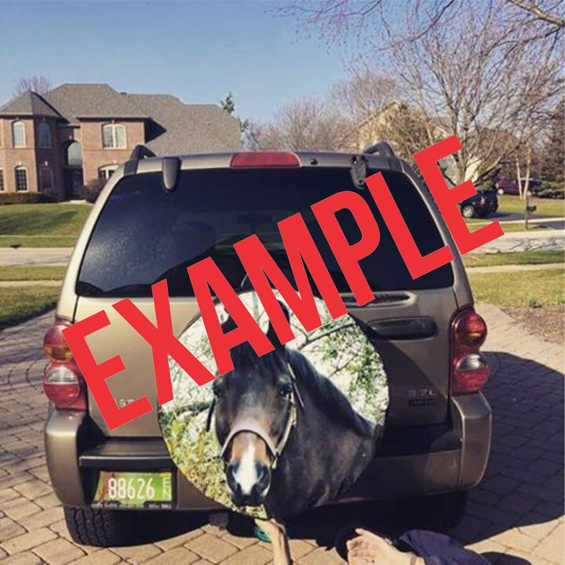 May include: A brown SUV with a spare tire cover featuring a horse's head. The spare tire cover is a brown and white photo of a horse's head with a green background. The license plate reads "88626".