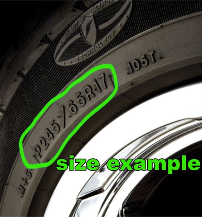 May include: Close-up of a black tire with the size "P245/65R17" printed on the sidewall.