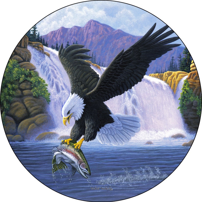 May include: A bald eagle with white head and tail feathers soars above a waterfall, clutching a silver trout in its talons. The eagle is flying over a cascading waterfall with a mountain range in the background.
