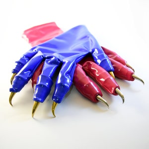 May include: A pair of blue and pink latex gloves with long, sharp, gold claws. The gloves are folded over each other.
