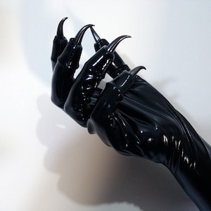 May include: Black leather gloves with long, sharp claws. The gloves are shiny and appear to be made of a wet look material.