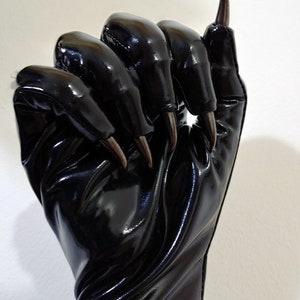 May include: Black leather gloves with long, sharp claws. The gloves are shiny and have a textured surface.