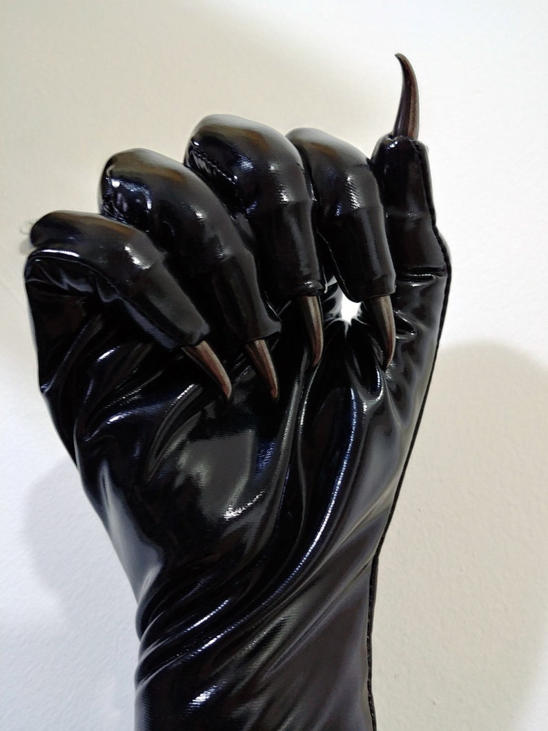 May include: Black leather gloves with long, sharp claws. The gloves are shiny and have a textured surface.