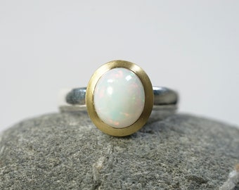 Opal ring with matt gold rim, oval