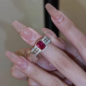 Anillo de compromiso de plata de ley 925 con rubí rojo sintético de talla esmeralda de 2 quilates y detalles de moissanita.