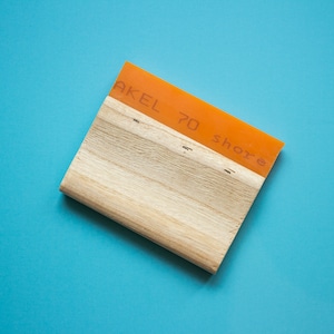 Könnte beinhalten: Orangener Rakel mit einem Holzgriff. Der Rakel hat den Text "AKEL 70 shore" aufgedruckt.