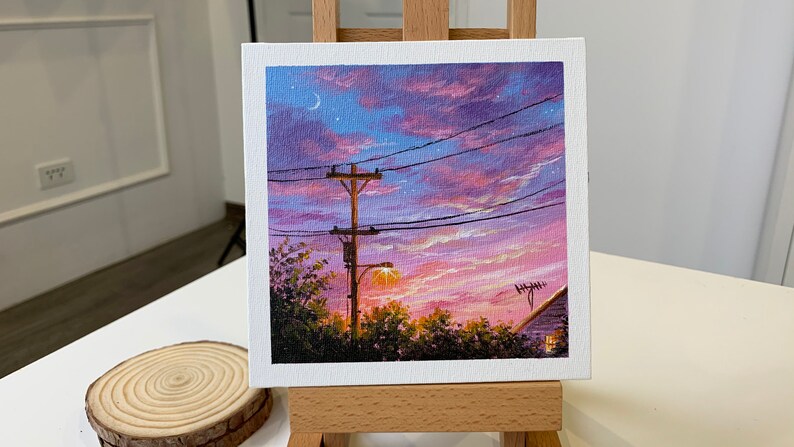 May include: A painting of a sunset with a power line and a streetlight in the foreground. The sky is a mix of pink, purple, and blue with a crescent moon and stars.