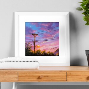 May include: A framed painting of a sunset with a crescent moon in the sky. The painting features a wooden utility pole with power lines and a streetlight. The sky is a vibrant mix of pink, purple, and orange.