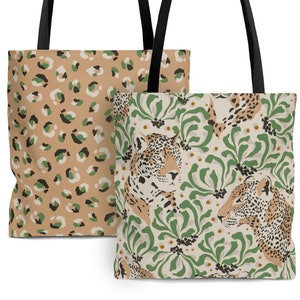 May include: Two tote bags with different designs. One bag features a leopard print pattern in shades of brown, beige, and green. The other bag has a cream background with green foliage and a brown and black jaguar print.