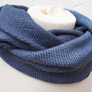 Könnte beinhalten: Ein blauer gestrickter Infinity-Schal mit einem strukturierten Muster.