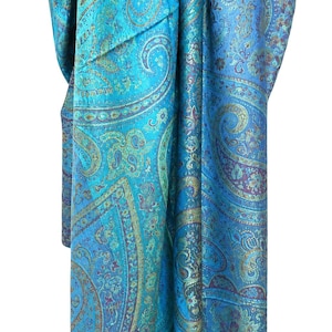 May include: A vibrant turquoise scarf featuring an intricate, repeating paisley pattern in shades of deep blue, purple, and metallic gold. The fabric displays a subtle sheen and a complex, dense design of swirling teardrop motifs and floral elements.
