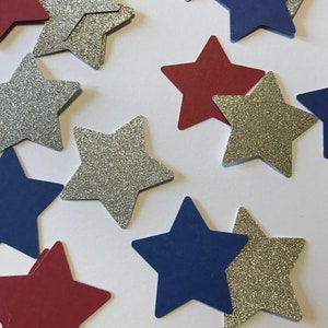 May include: Assortment of silver glitter, red, and blue paper stars. The stars are cut in a five-pointed shape.