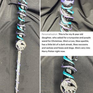 K&ouml;nnte beinhalten: Ein handgefertigter Fantasy-Zauberstab mit einem dunkelvioletten, t&uuml;rkisfarbenen und silbernen Design. Der Zauberstab hat einen dunkelvioletten Kristallaufsatz, ein silbernes Wolfsemblem und ein spiralf&ouml;rmiges Design.