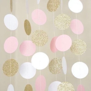 May include: A garland of pink, white, and gold circles. The circles are made of paper and have a glitter finish. The garland is perfect for a party or special occasion.