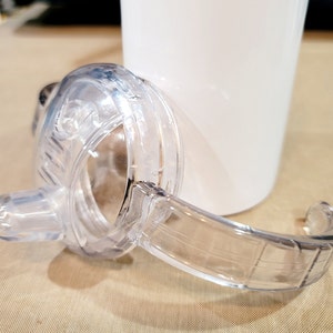 May include: Clear plastic lid with a handle for a tumbler or cup. The lid has a spout for easy drinking.