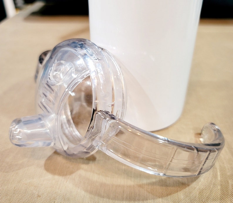 May include: Clear plastic lid with a handle for a tumbler or cup. The lid has a spout for easy drinking.