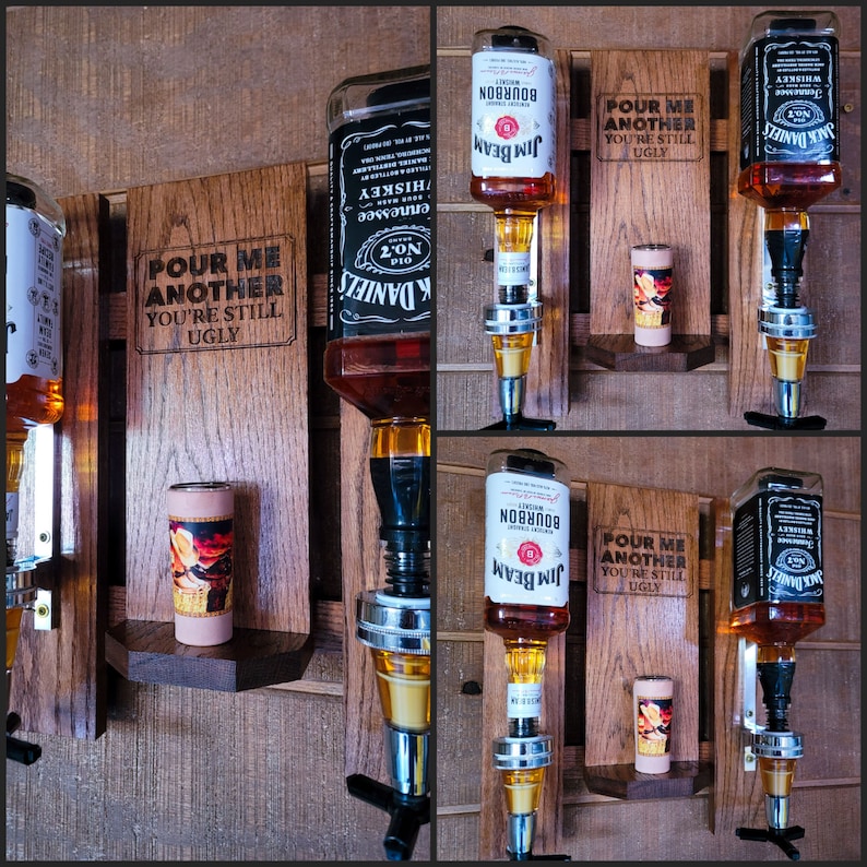 Puede incluir: Dispensadores de botellas de licor de madera con vasos de chupito adjuntos. Los dispensadores contienen botellas de Jack Daniel's y Jim Beam. Las tablas de madera tienen el texto "POUR ME ANOTHER YOU'RE STILL UGLY" grabado.