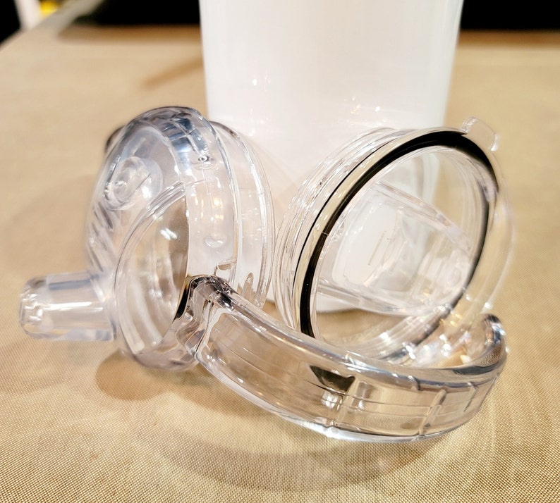 May include: Clear plastic lid with a black rubber seal and a clear plastic straw. The lid is designed for a tumbler or travel mug.