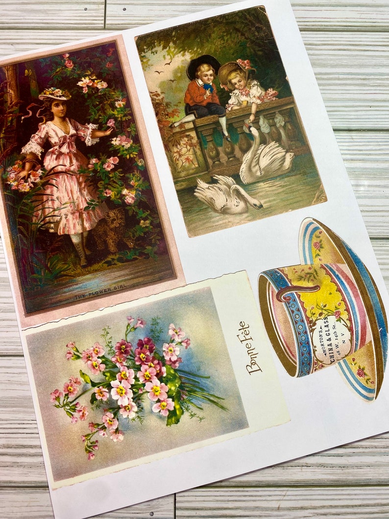 Pu&ograve; includere: Quattro cartoline vintage raffiguranti una ragazza in un vestito rosa in piedi in un giardino, due bambini che nutrono cigni su un ponte, un mazzo di fiori rosa e una tazza da t&egrave; con un design blu e giallo. La tazza da t&egrave; ha il testo "Morton's China & Glass 8 W. 14th St. N.Y."