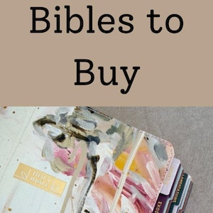 May include: Aesthetic Bibles with painted covers and gold lettering. The image shows a stack of books with colorful tabs, and the text "Aesthetic Bibles to Buy". The books are on a brown knitted surface.
