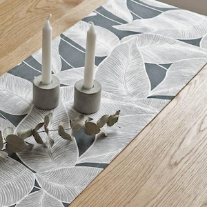 Elegante tafelloper "Eden" met een verfijnd bladmotief in antraciet en grijs – Modern decoratief kussen in een tropische monochrome look