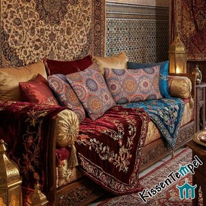 May include: A richly decorated sofa with multiple pillows and a patterned throw. The pillows feature circular designs in shades of orange, blue, and purple. The throw and sofa are in shades of red and gold.