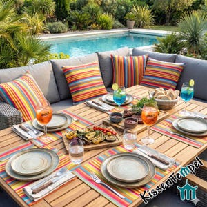 Puede incluir: Escena de comedor al aire libre con una mesa de madera, asientos acolchados grises y coloridos cojines a rayas. La mesa est&aacute; puesta con platos, cubiertos y vasos. Se sirven verduras a la parrilla y pan, junto con bebidas. Una piscina es visible en el fondo.