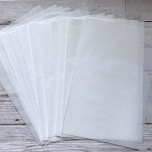 Pu&ograve; includere: Un mucchio di fogli di carta velina bianca. La carta &egrave; sottile e traslucida.