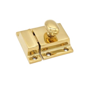 May include: A polished brass cabinet latch with a rounded knob. The latch has a rectangular shape and is designed to be mounted on a cabinet door.
