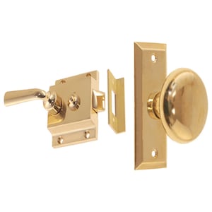 May include: A brass door knob set with a lever handle, a rectangular backplate, and a round doorknob. The set includes a latch and strike plate. The hardware is a shiny gold color.