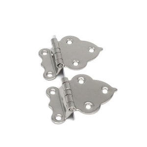 May include: Two silver-toned decorative hinges with a decorative, ornate design. The hinges are closed and ready to be installed.