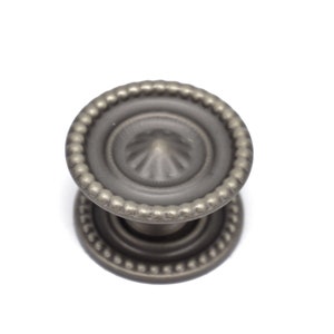 May include: A silver-toned cabinet knob with a beaded edge and a decorative, fluted center.