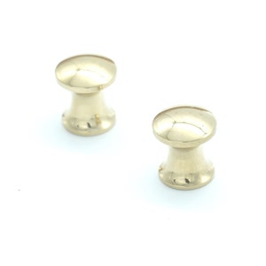 May include: Two gold-toned metal cabinet knobs with a rounded top and a slightly flared base.