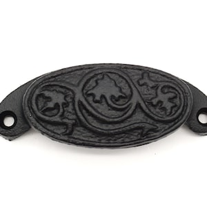 May include: Black cast iron drawer pull with a decorative floral design.