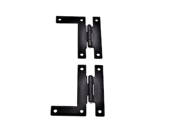 May include: Two black metal hinges with a 90-degree angle. The hinges are designed to be used for doors or gates.