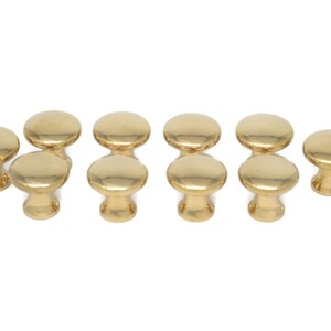 May include: A collection of ten shiny, gold-colored cabinet knobs. Each knob has a rounded top and a short, cylindrical base. The knobs are arranged in two rows, showcasing their polished finish and simple design. Ideal for furniture upgrades.