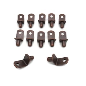 May include: A collection of bronze-colored shelf supports and shelf pins. The shelf pins have a cylindrical peg and a flat top with a hole. Two corner shelf supports are also included.