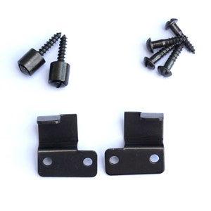 May include: Two black metal brackets with two holes each, and six black screws with round heads.