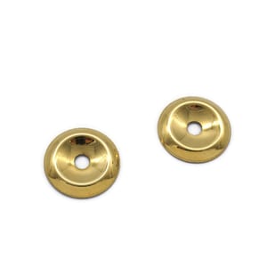May include: Two gold-colored metal decorative round embellishments with a raised center and a hole in the middle.