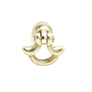 May include: A gold-toned metal cabinet pull with a ring design and two curved handles.