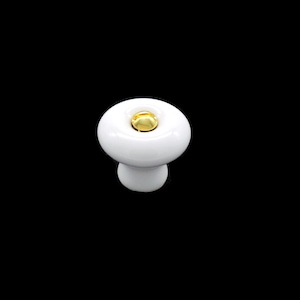 May include: White ceramic cabinet knob with a gold accent. The knob is round and has a mushroom-like shape.