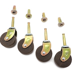 May include: Four brown furniture casters with gold-colored metal brackets and stems, plus four matching metal fasteners. The casters have a classic design, suitable for various furniture pieces. The wheels are approximately 1.5 inches in diameter.