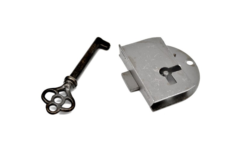 May include: A silver keyhole lock with a key. The key is made of metal and has a decorative design.
