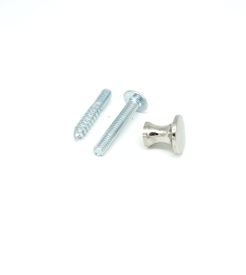 May include: A set of silver-toned cabinet hardware, including a small knob and two screws. The knob has a rounded top and a flared base. The screws are threaded, one with a pointed end and the other with a flat head.