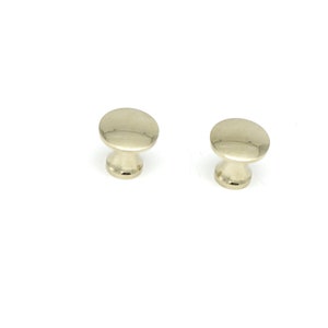 May include: Two polished nickel cabinet knobs with a round top and a short, cylindrical base.