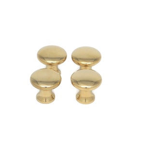 May include: Four gold-colored cabinet knobs with a smooth, rounded design. Each knob has a circular top and a cylindrical base, all in a shiny, metallic finish. The knobs are arranged in two pairs, suitable for furniture hardware.